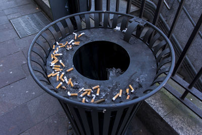 High angle view of cigarette butts in garbage can