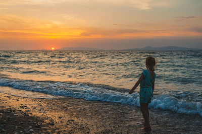 Full length of girl standing on shore at beach