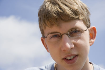 Close-up portrait of young man against sky