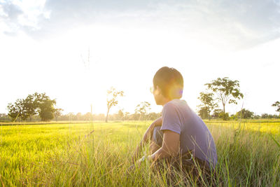 Side view of man on field against sky