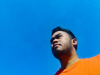 Portrait of young man against blue sky