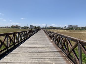 Footbridge over footpath against sky