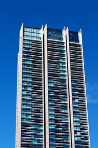 Low angle view of modern building against blue sky