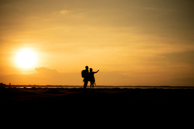 Silhouette man riding horse at sunset