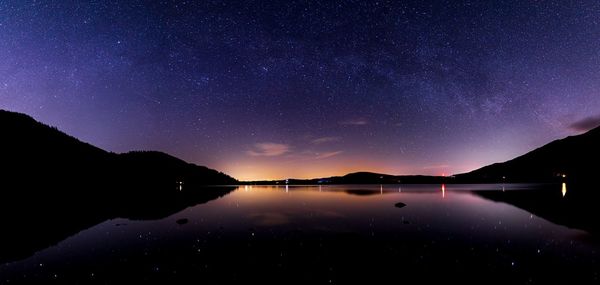 Scenic view of lake against sky at night