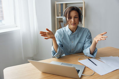 Portrait of young woman using mobile phone at home