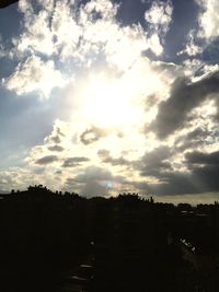 Silhouette buildings against cloudy sky