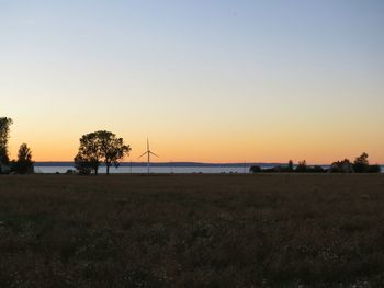 Silhouette of trees on field against clear sky