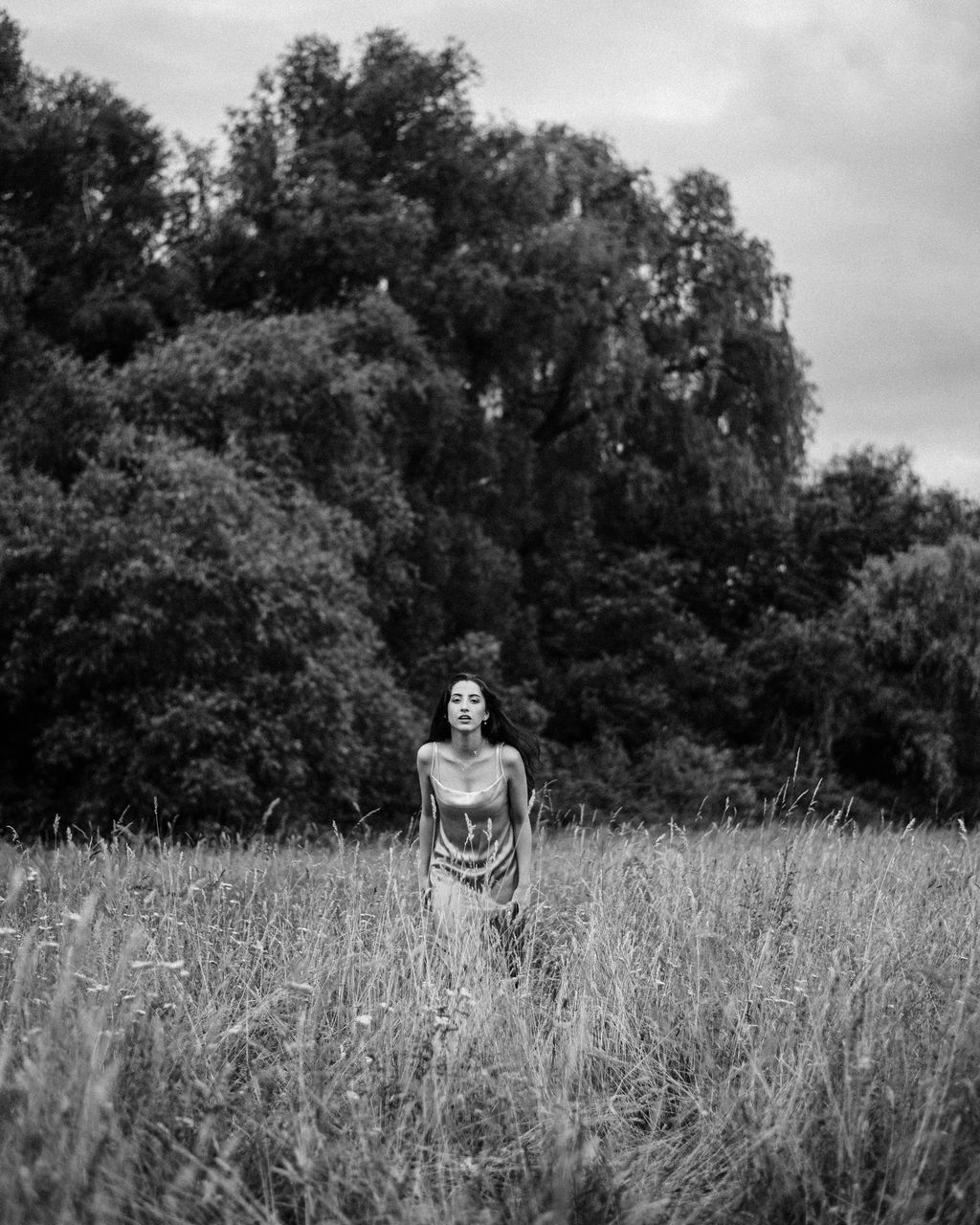plant, black and white, tree, grass, one person, monochrome photography, nature, land, growth, monochrome, field, rural area, leisure activity, sky, adult, day, front view, casual clothing, lifestyles, standing, landscape, beauty in nature, person, young adult, tranquility, outdoors, full length, forest, men, three quarter length, women, portrait, environment, cloud, non-urban scene, rural scene, tranquil scene, flower, child