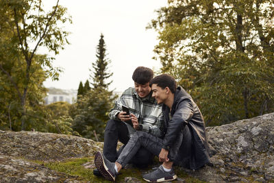 Young men using smart phone outdoors