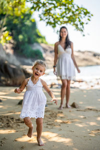 Full length of young woman standing at beach