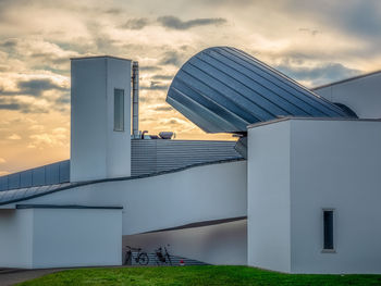 Modern building against sky during sunset