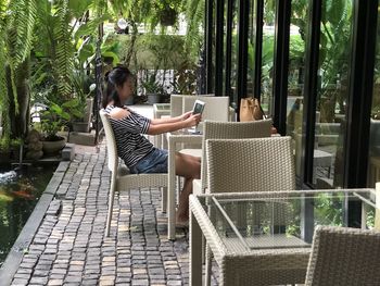 Side view of woman sitting on chair in restaurant