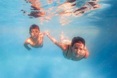 Portrait of mother and son swimming in pool