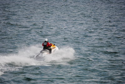 Rear view of man riding jet ski in sea