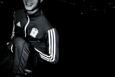 Man standing against black background