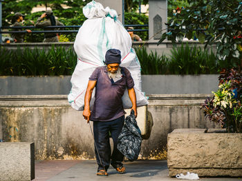 Rear view of man walking on footpath