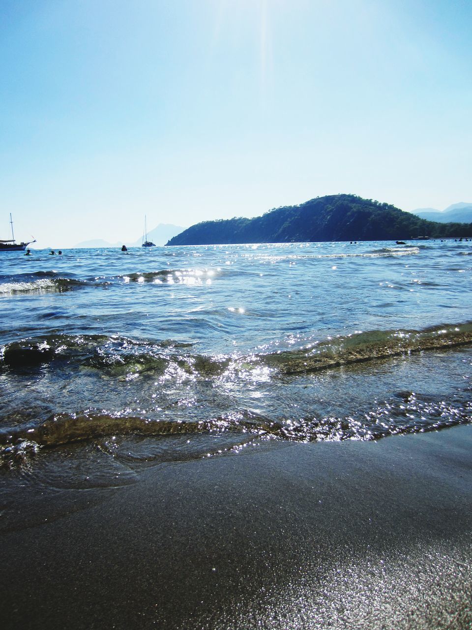 water, sea, clear sky, tranquil scene, scenics, beach, tranquility, beauty in nature, copy space, nature, blue, shore, mountain, wave, idyllic, sand, sky, horizon over water, outdoors, coastline