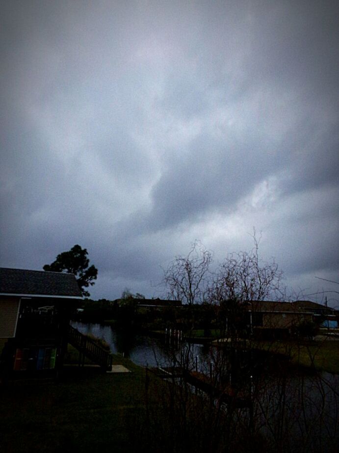 STORM CLOUDS OVER HOUSE AGAINST DRAMATIC SKY