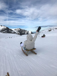 Man skiing on snowcapped mountain against sky