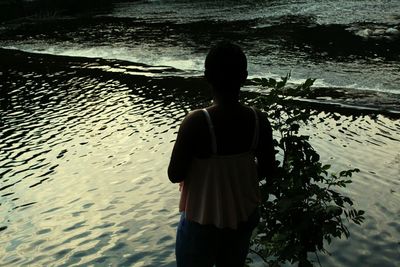 Rear view of silhouette woman standing at beach