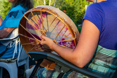 Midsection of woman holding multi colored umbrella