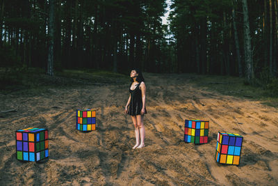 Full length of woman standing on tree trunk