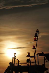 Silhouette ship in sea against sky during sunset