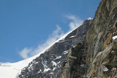 Low angle view of snowcapped mountain against sky