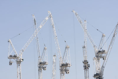 Cranes at construction site against clear sky