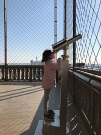 Girl looking through coin-operated binoculars

