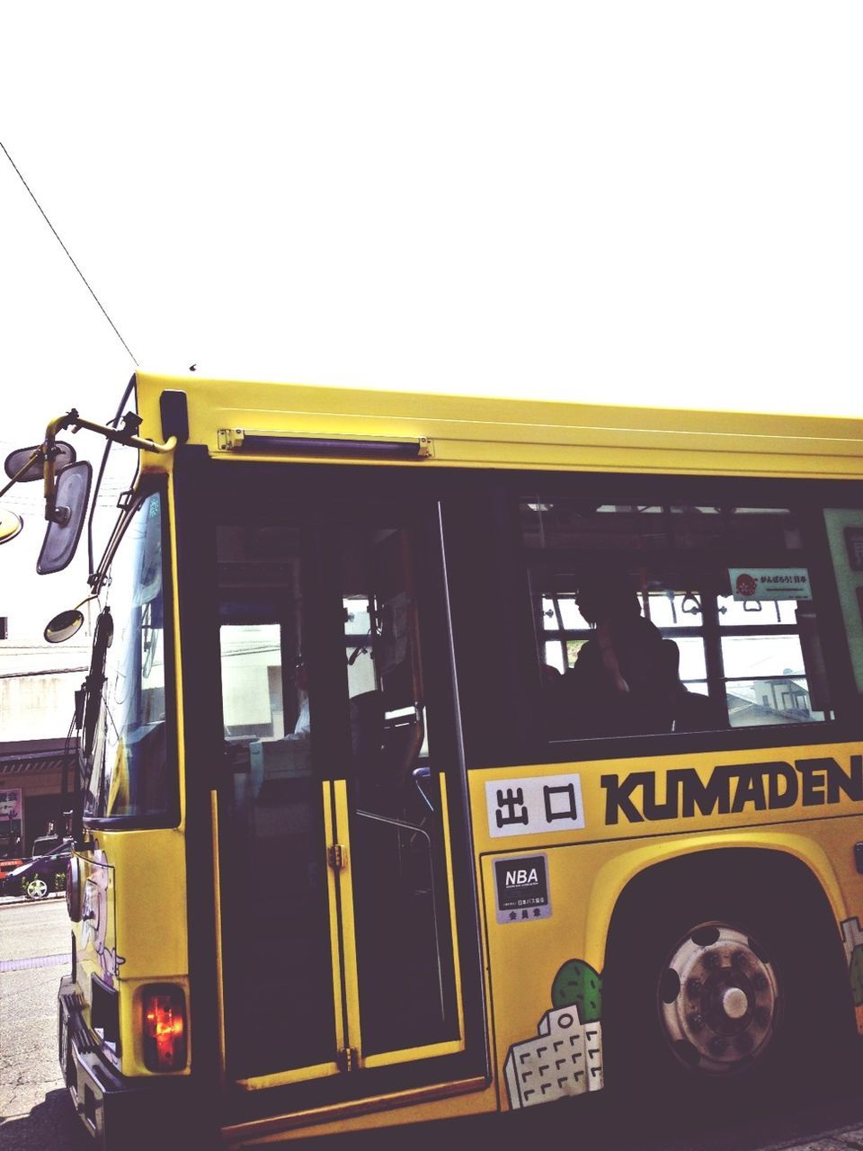 transportation, mode of transport, clear sky, land vehicle, architecture, built structure, yellow, building exterior, car, text, window, communication, outdoors, western script, train - vehicle, public transportation, sky, copy space, day, street