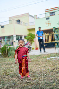 Full length portrait of girl wearing sari while standing in yard