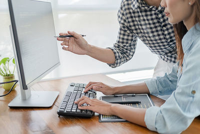 Midsection of woman using laptop on table