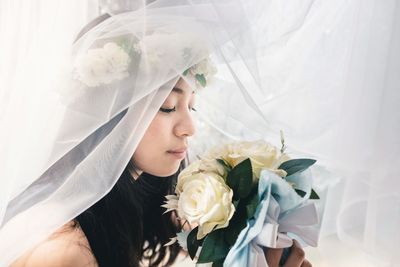 Close-up of bride smelling flower bouquet