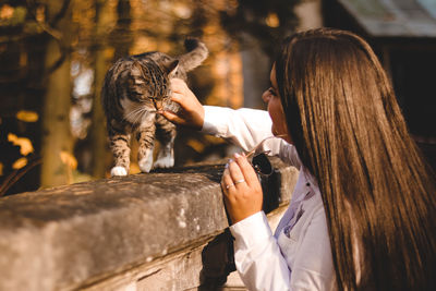 Midsection of woman with cat outdoors