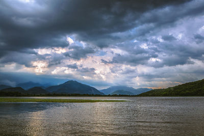 Scenic view of lake against dramatic sky