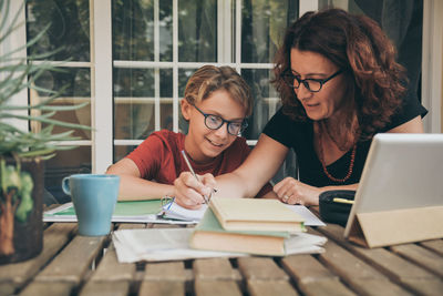 Mother helping boy in study at home