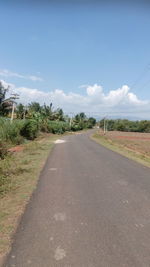 Empty road by landscape against sky