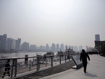Full length of man on railing against buildings in city