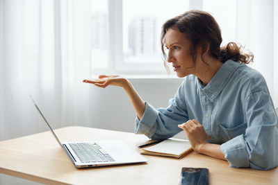 Businesswoman using laptop at table