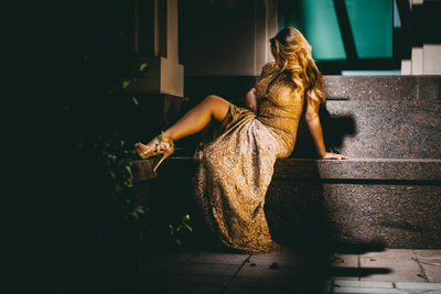 Rear view of woman sitting on staircase