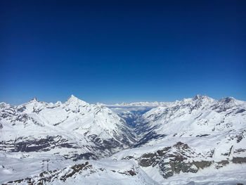 Scenic view of snowcapped mountains against clear blue sky