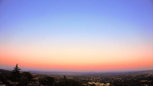 Aerial view of city buildings against clear sky during sunset