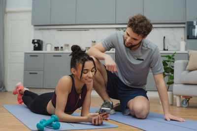 Side view of young woman sitting in gym