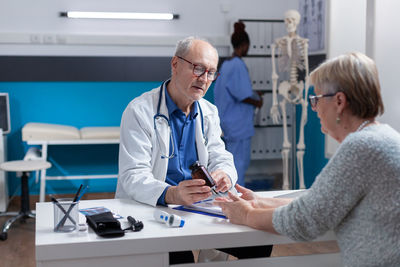 Doctor prescribing medicine to patient in clinic