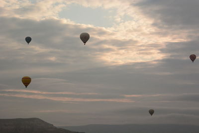 Hot air balloons flying against sky during sunset