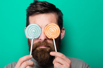 Close-up portrait of man wearing mask against blue background