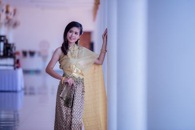 Young woman standing against wall