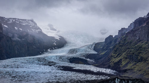 Scenic view of waterfall against sky during winter